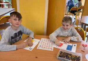 Dzieci kolorują flagi państw Europy podczas zajęć świetlicowych.