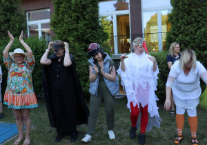 Nauczyciele w kostiumach podczas występu artystycznego na pikniku.